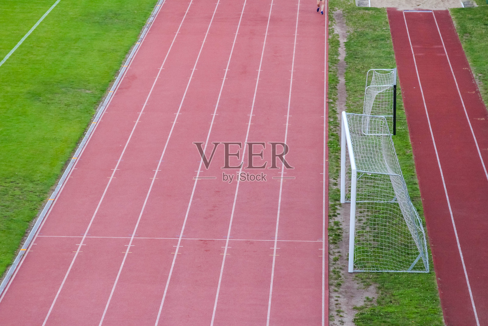 红色田径跑道上多条平行跑道，配有精确的白色边界标记照片摄影图片