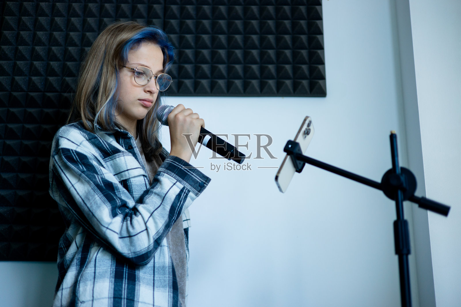 青少年女孩在录音室用麦克风唱歌照片摄影图片
