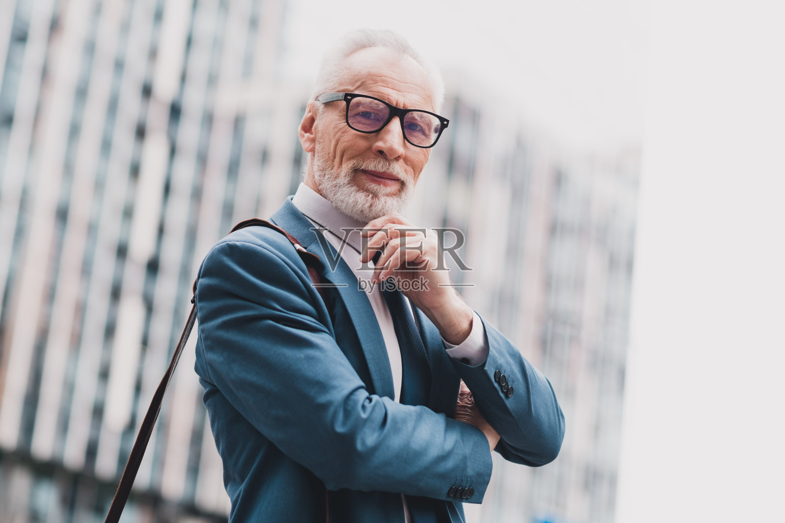 自信的高级商务人士穿着正式服装站在户外，展现专业形象照片摄影图片