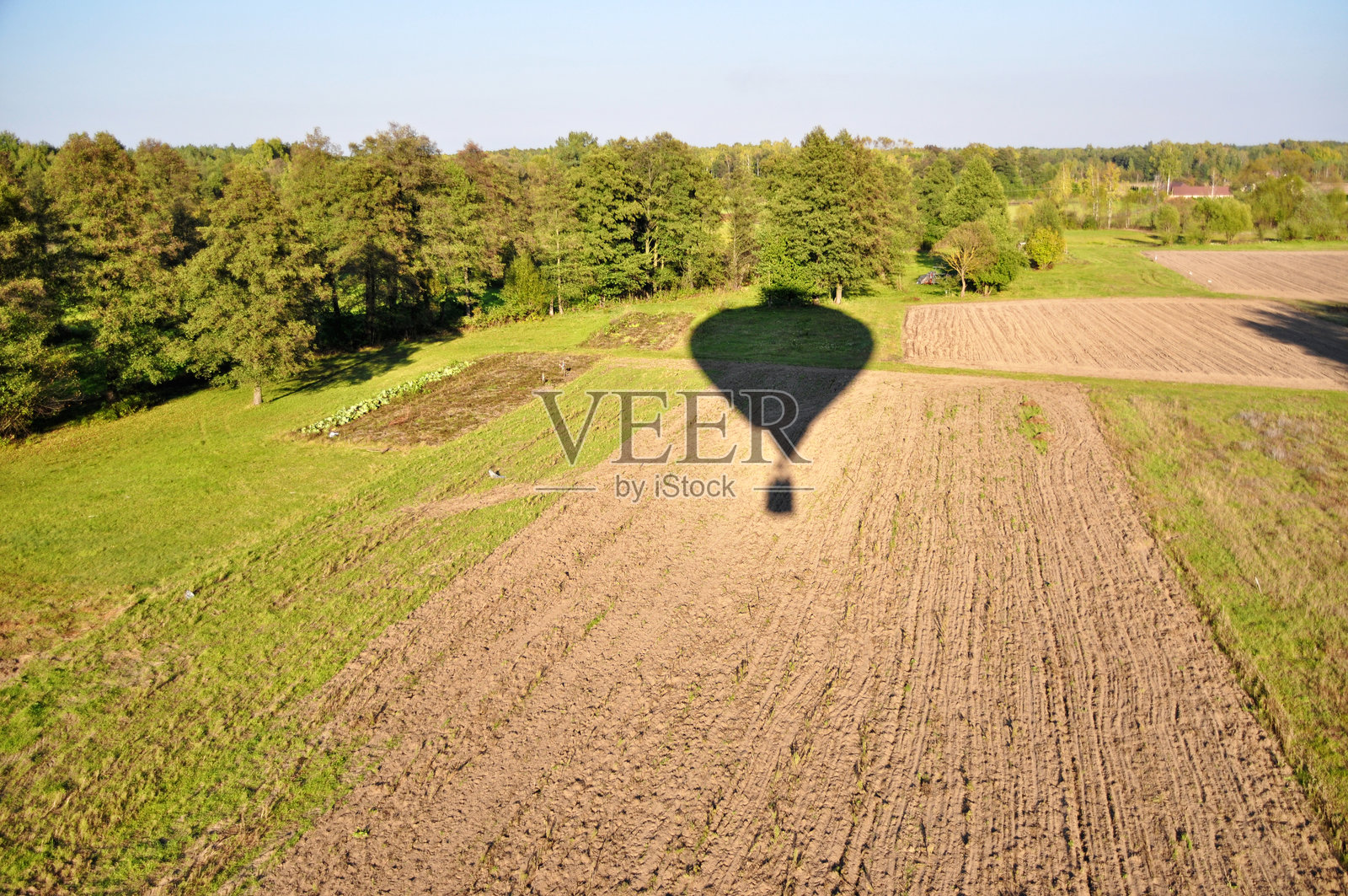 热气球的影子在拼布农田上滑翔，从篮子里俯瞰的阳光明媚的日子照片摄影图片