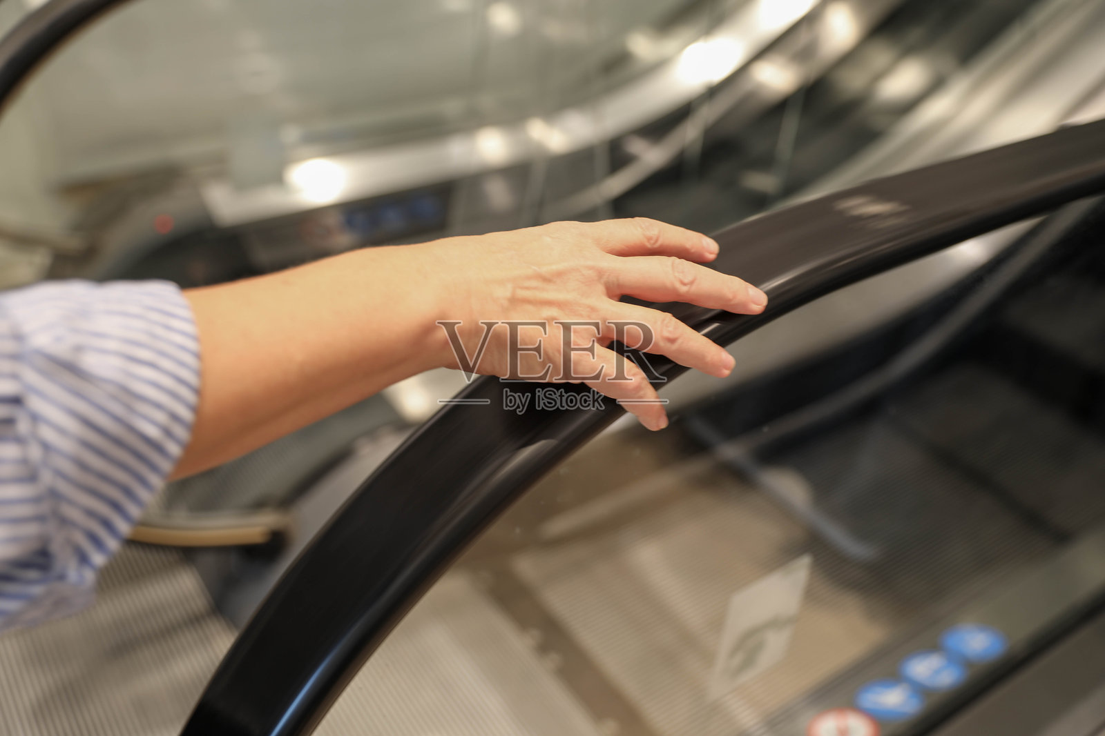 美丽的50岁以上女性在购物时乘坐自动扶梯上下楼层照片摄影图片