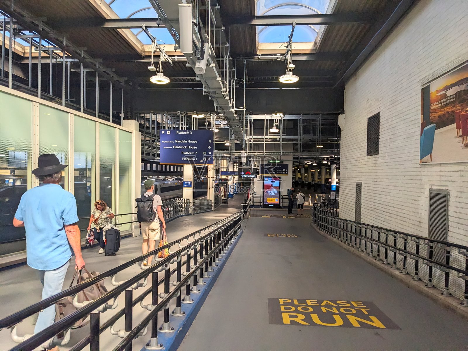 乘客们带着行李走向位于英格兰伦敦市中心的尤斯顿车站月台。照片摄影图片