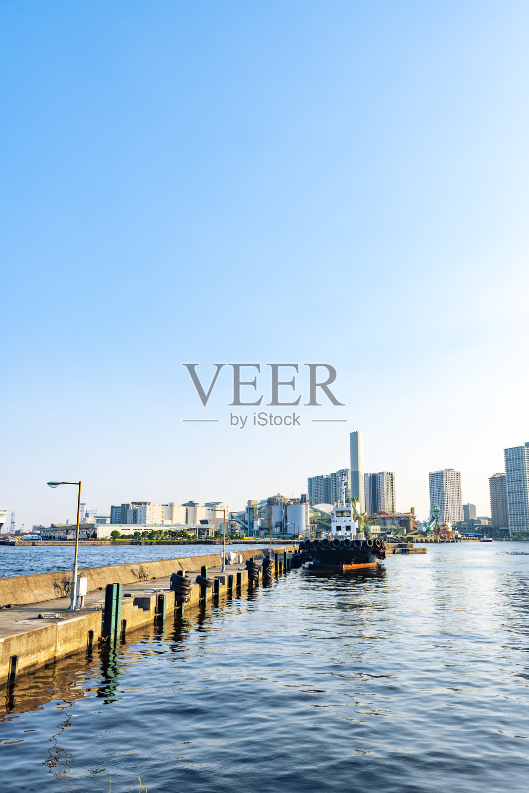 在日本东京港区的芝浦码头停靠的船只与品川天际线照片摄影图片