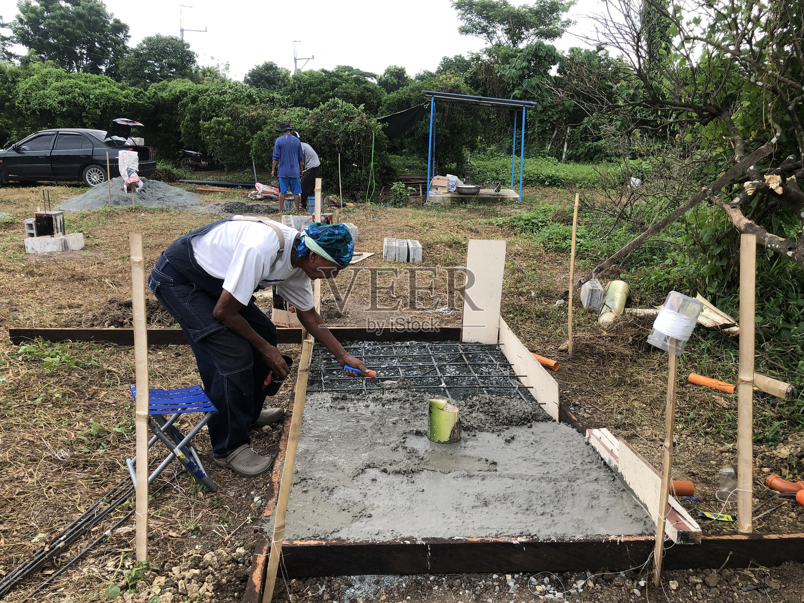 建筑工人正在将混凝土混合物倒在化粪池的底板上。照片摄影图片