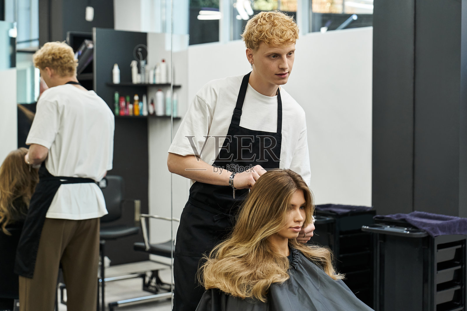 现代美容院中的时尚变身，熟练的双手为美丽的秀发打造造型照片摄影图片