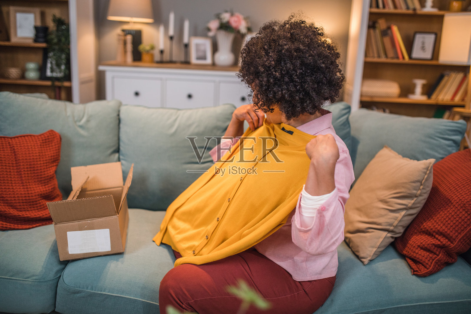 多种族女性享受拆开一个纸箱，这是她在线订购的衣物包裹。照片摄影图片