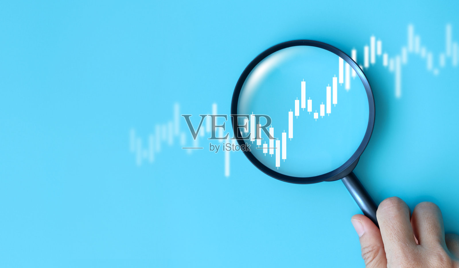 手握放大镜分析数字金融股票图表。数据分析、投资研究、交易策略和金融市场概念，背景为蓝色。商业股票市场。照片摄影图片