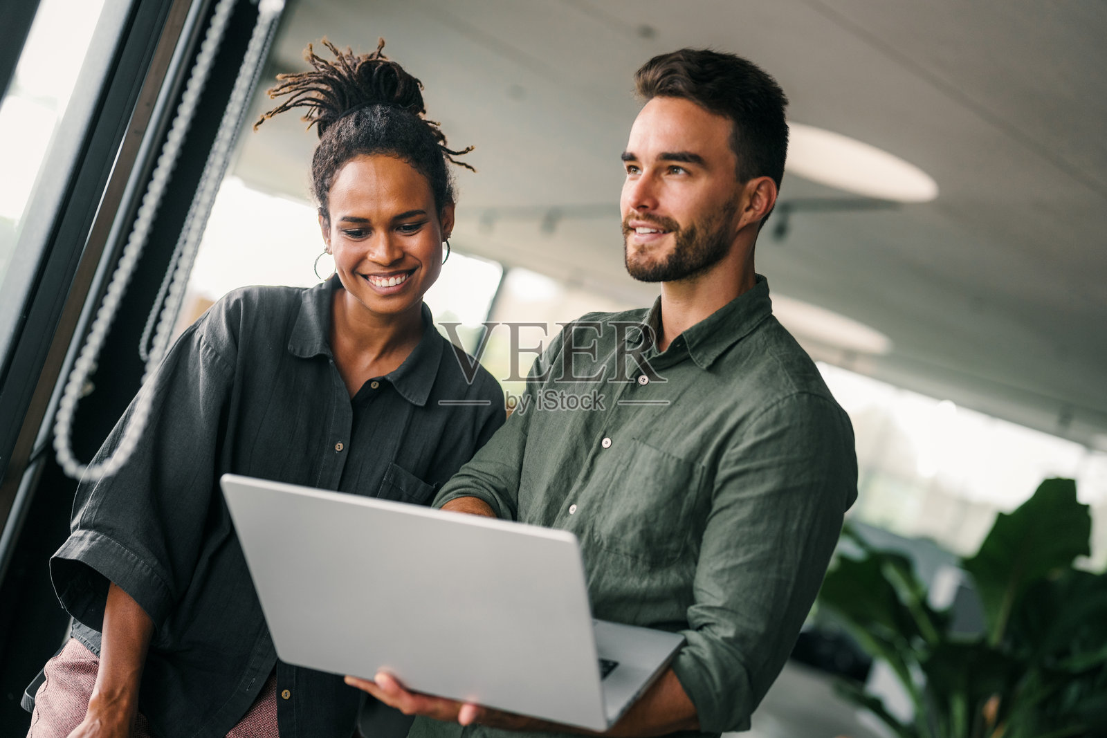 两位快乐的多元文化商业团队成员在公司办公室工作和交谈照片摄影图片