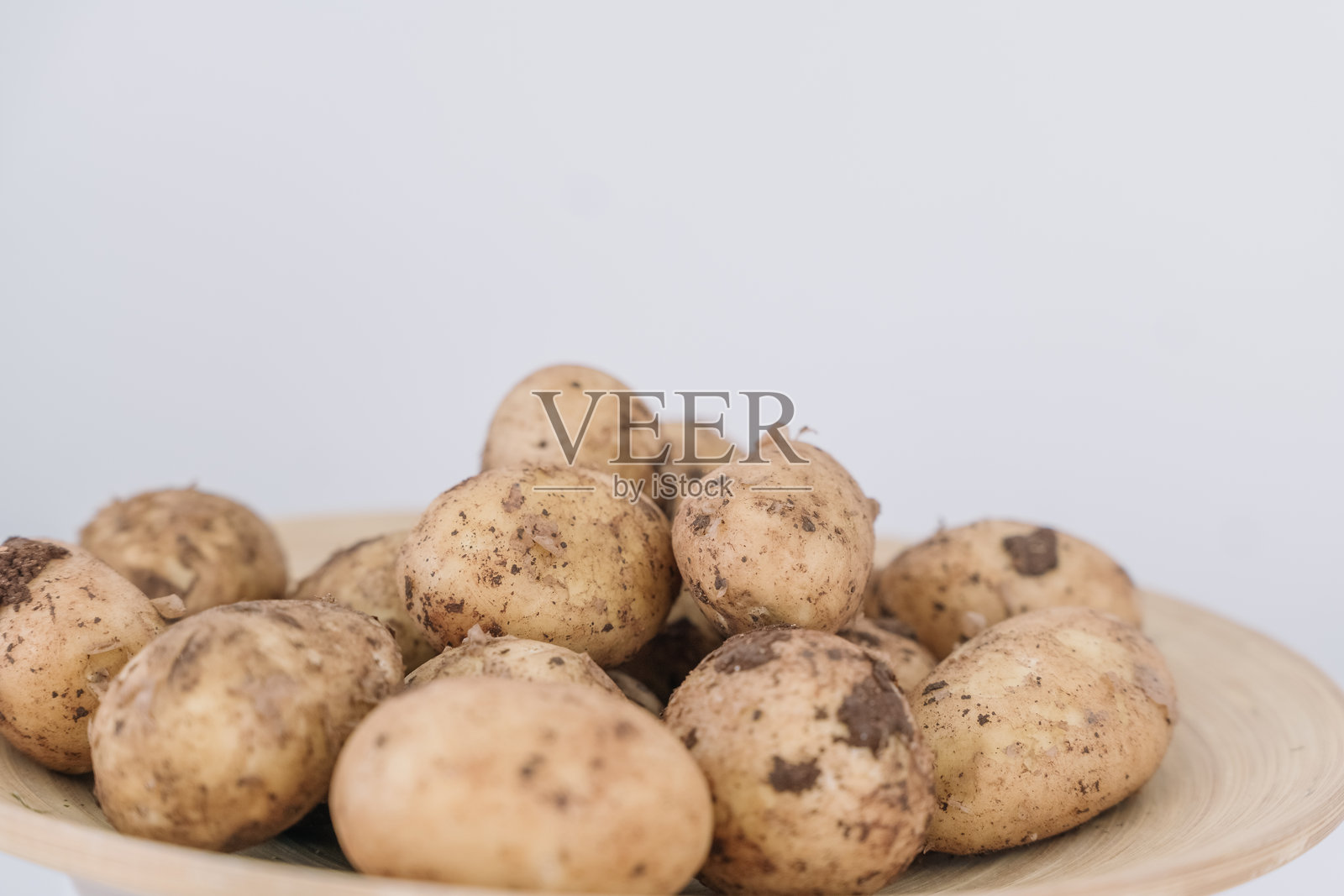 新鲜采摘的小土豆放在明亮厨房的木盘上照片摄影图片