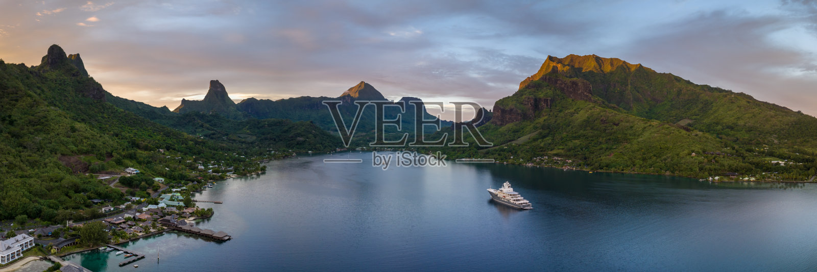 豪华游艇停靠在塔希提岛摩雷阿岛的库克湾，夕阳西下。照片摄影图片