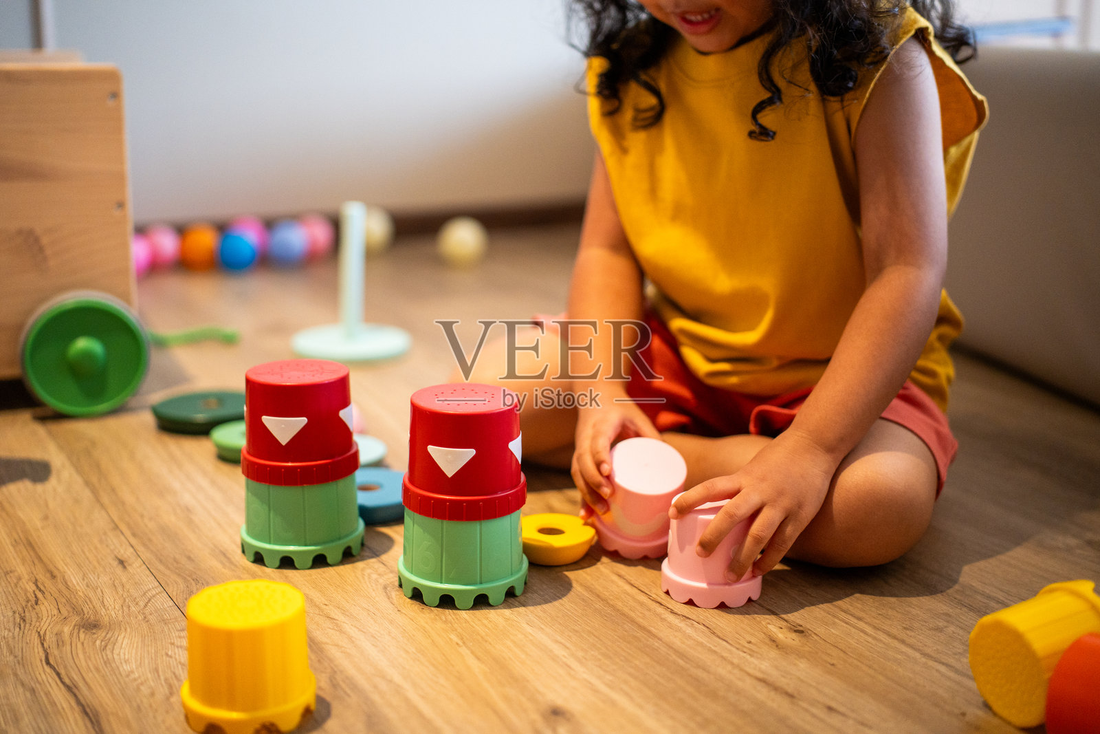 学龄前儿童在家玩玩具。木制彩虹，环保玩具。儿童有序的储物空间促进学习、乐趣和可持续性，营造安全的环境。照片摄影图片