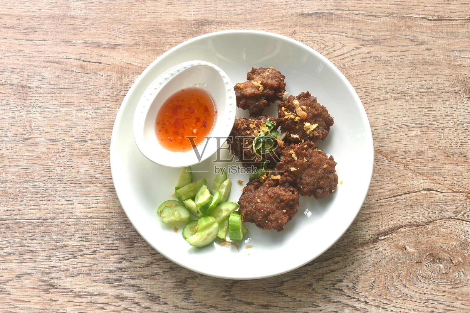 炸咸猪肉球配蒜蓉甜辣酱和黄瓜片照片摄影图片