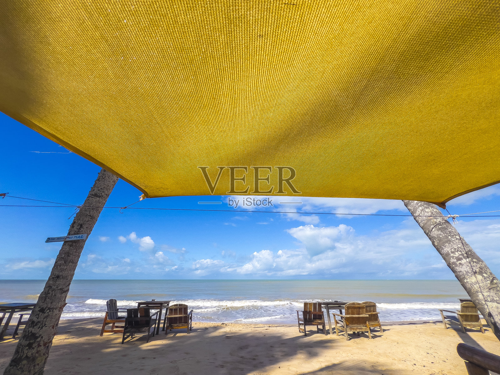 巴拉多卡伊海滩上的黄色遮阳篷和乡村风格椅子照片摄影图片