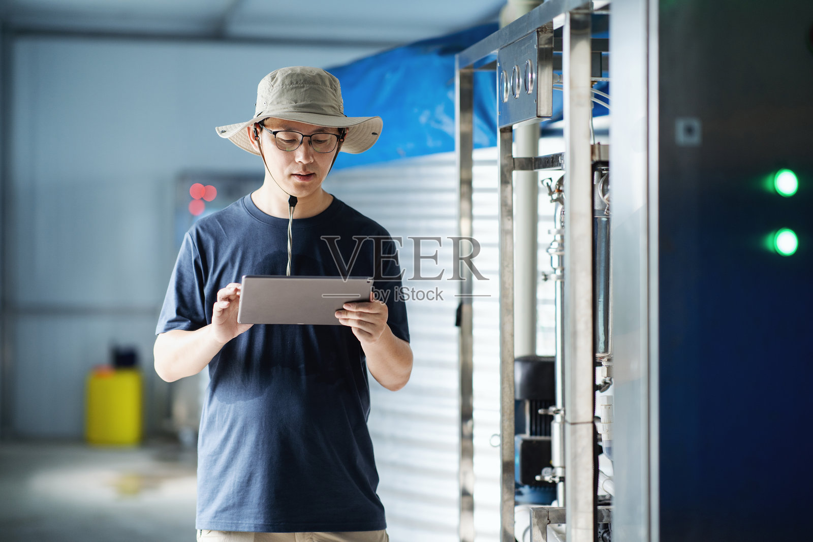 亚洲男性农民在温室控制室使用数字平板电脑工作照片摄影图片