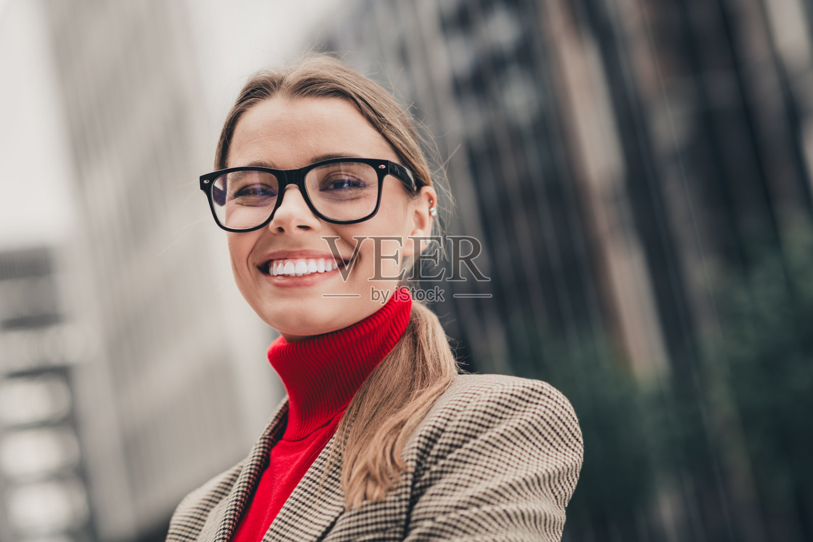 自信的女性企业家在城市环境中，展现出专业的风格和魅力，面带灿烂的微笑，穿着现代服装照片摄影图片