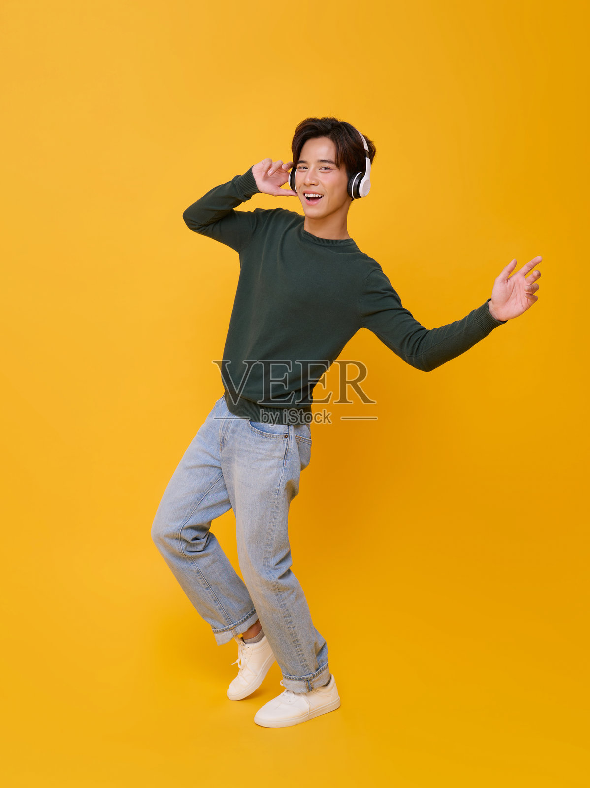 耳机音乐生活方式：快乐的年轻人在黄色背景下跳舞和聆听，愉快的全身姿势，留有广告、娱乐、社交媒体和积极营销的空白空间照片摄影图片