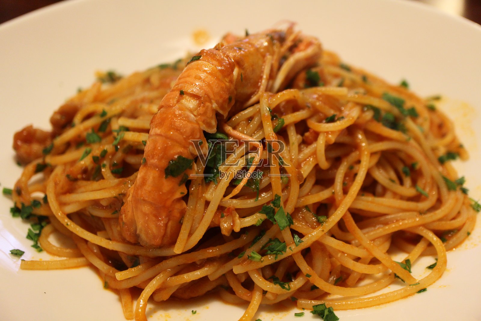 意大利美食：威尼斯的巴萨拉意大利面（配有明虾和番茄酱的意大利面）照片摄影图片