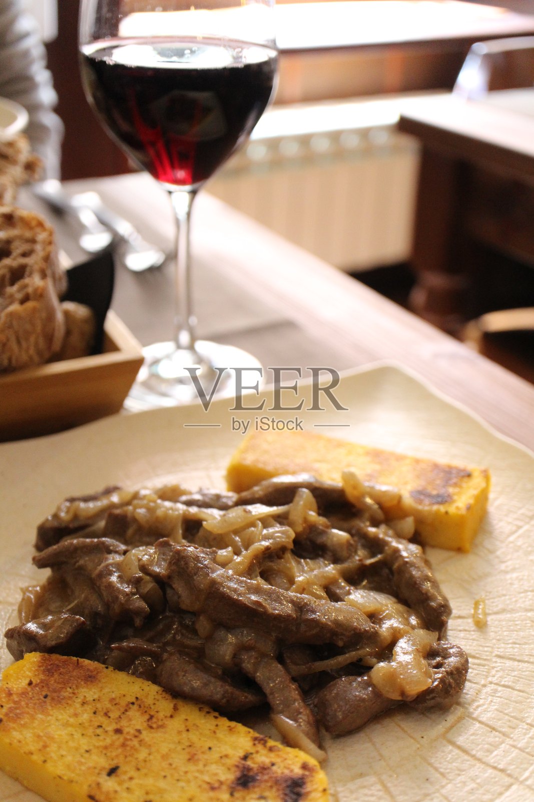 意大利美食：威尼斯风味的肝脏与洋葱配波伦塔，地点：意大利威尼斯照片摄影图片