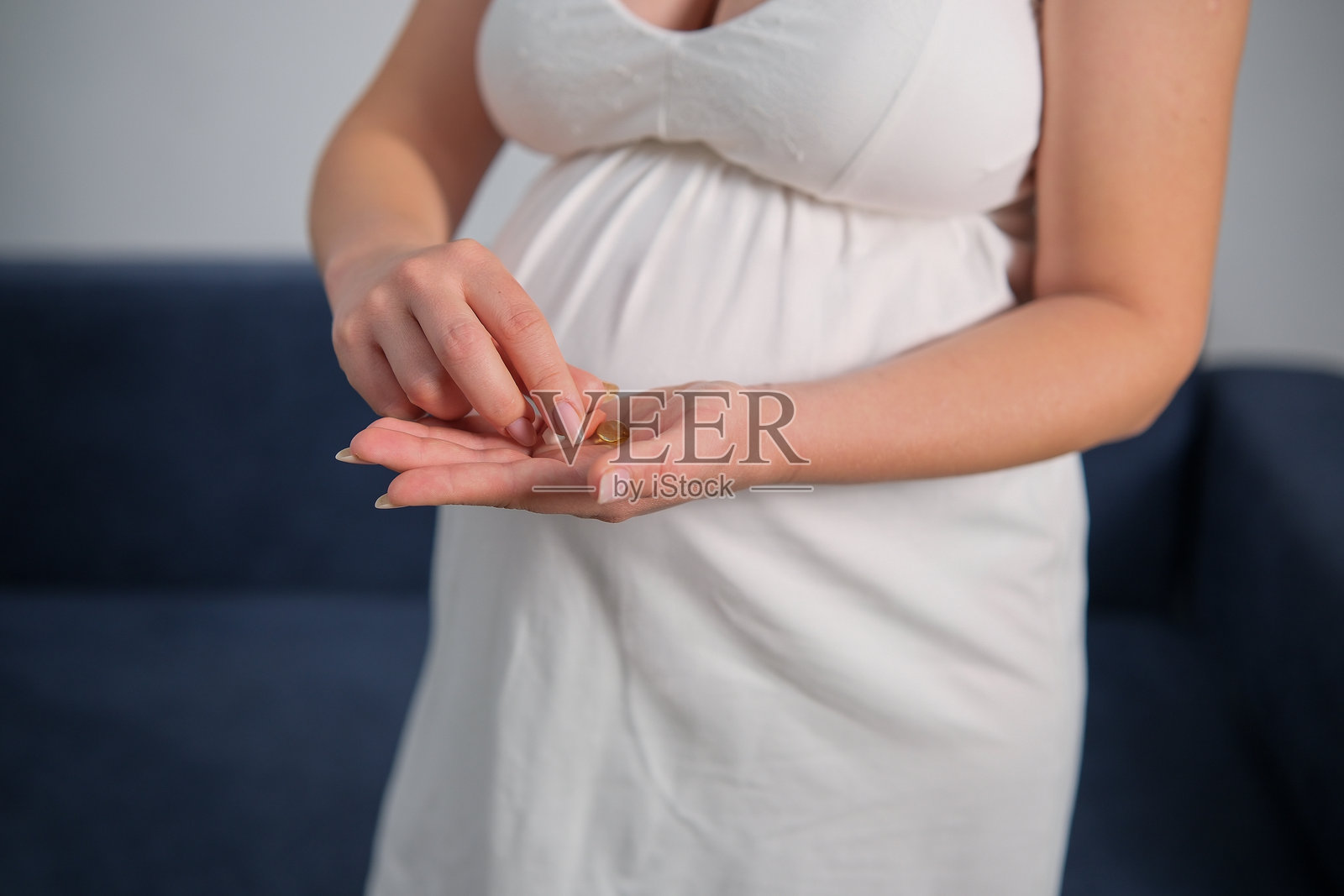 孕妇手中拿着药丸或维生素。照片摄影图片