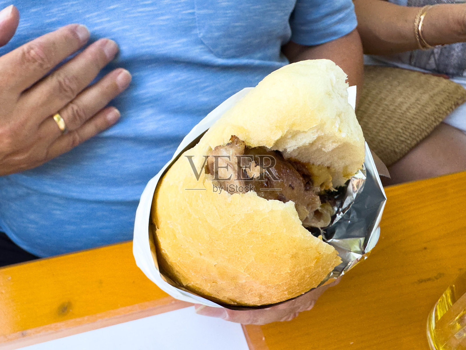 成年男性在户外桌子上用手势享受传统三明治照片摄影图片