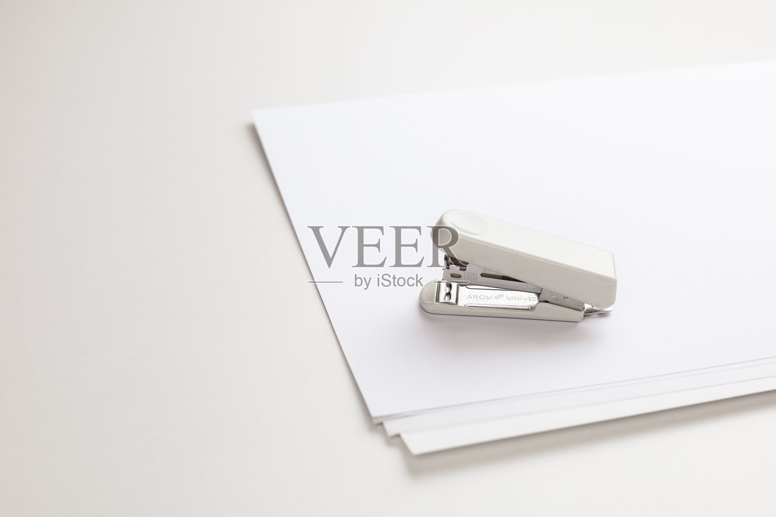 奶油色的订书机。照片摄影图片