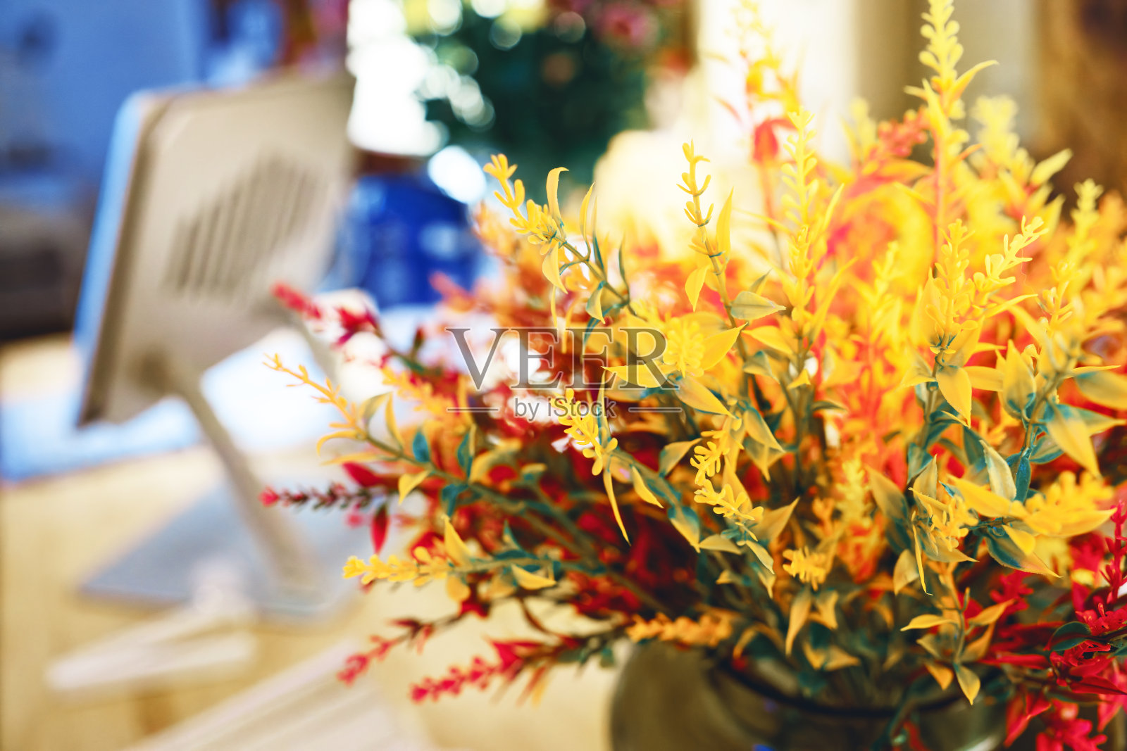 鲜艳的人造秋季花卉在舒适的环境中营造出温暖而宜人的氛围照片摄影图片