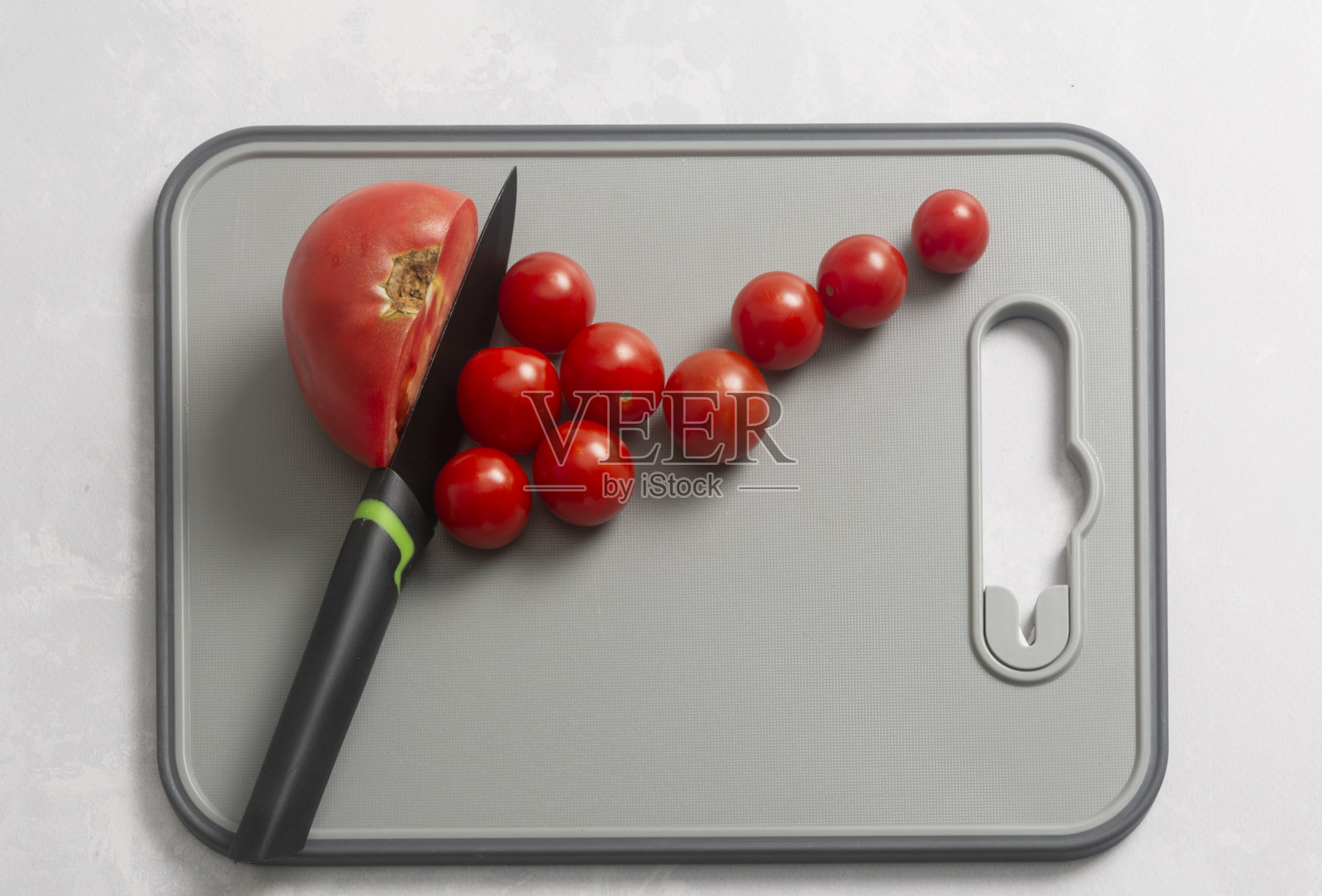 一个大番茄被刀切成小樱桃番茄形状的片，白色背景，孤立，俯视图。照片摄影图片