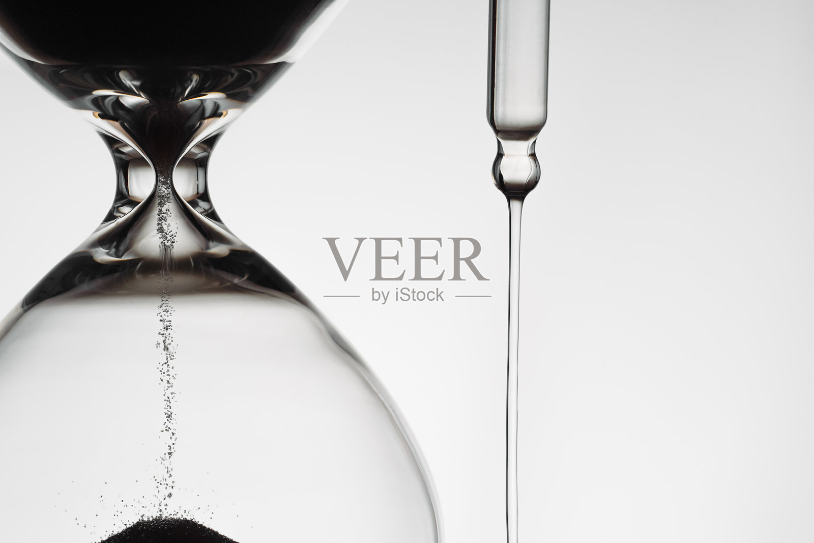 背光沙漏与滴管和滴落的精华液照片摄影图片