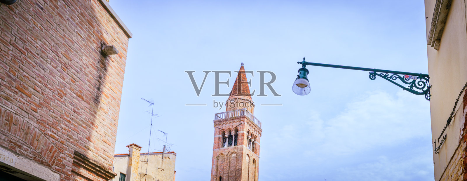 从运河和街道看到的威尼斯砖砌钟楼照片摄影图片