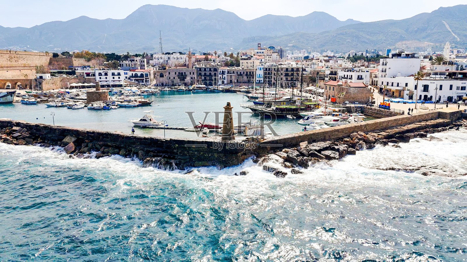 北塞浦路斯基尔尼亚港的鸟瞰图，展现了历史悠久的威尼斯建筑、碧蓝的地中海水域、游艇和基尔尼亚城堡，风景如画的海岸线，是著名的旅游胜地。照片摄影图片