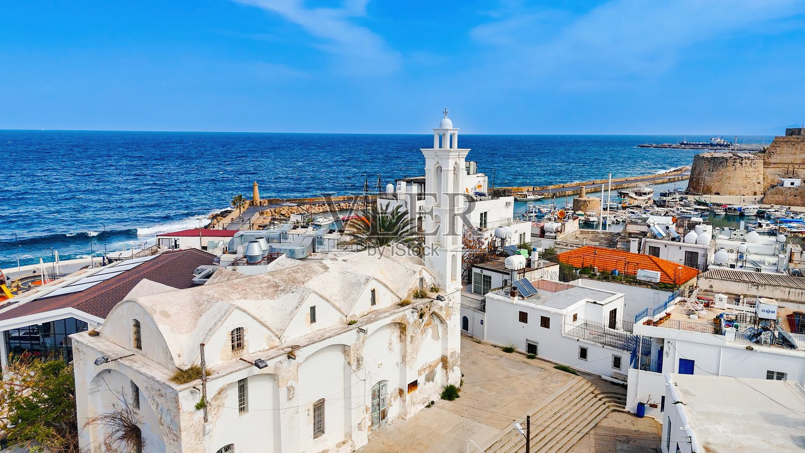 阿尔汉吉洛斯·米哈伊尔教堂的鸟瞰图，白色钟楼俯瞰着北塞浦路斯基尔尼亚的港口和海岸线，传统的地中海建筑和历史悠久的海滨小镇，旅游和文化旅游概念照片摄影图片