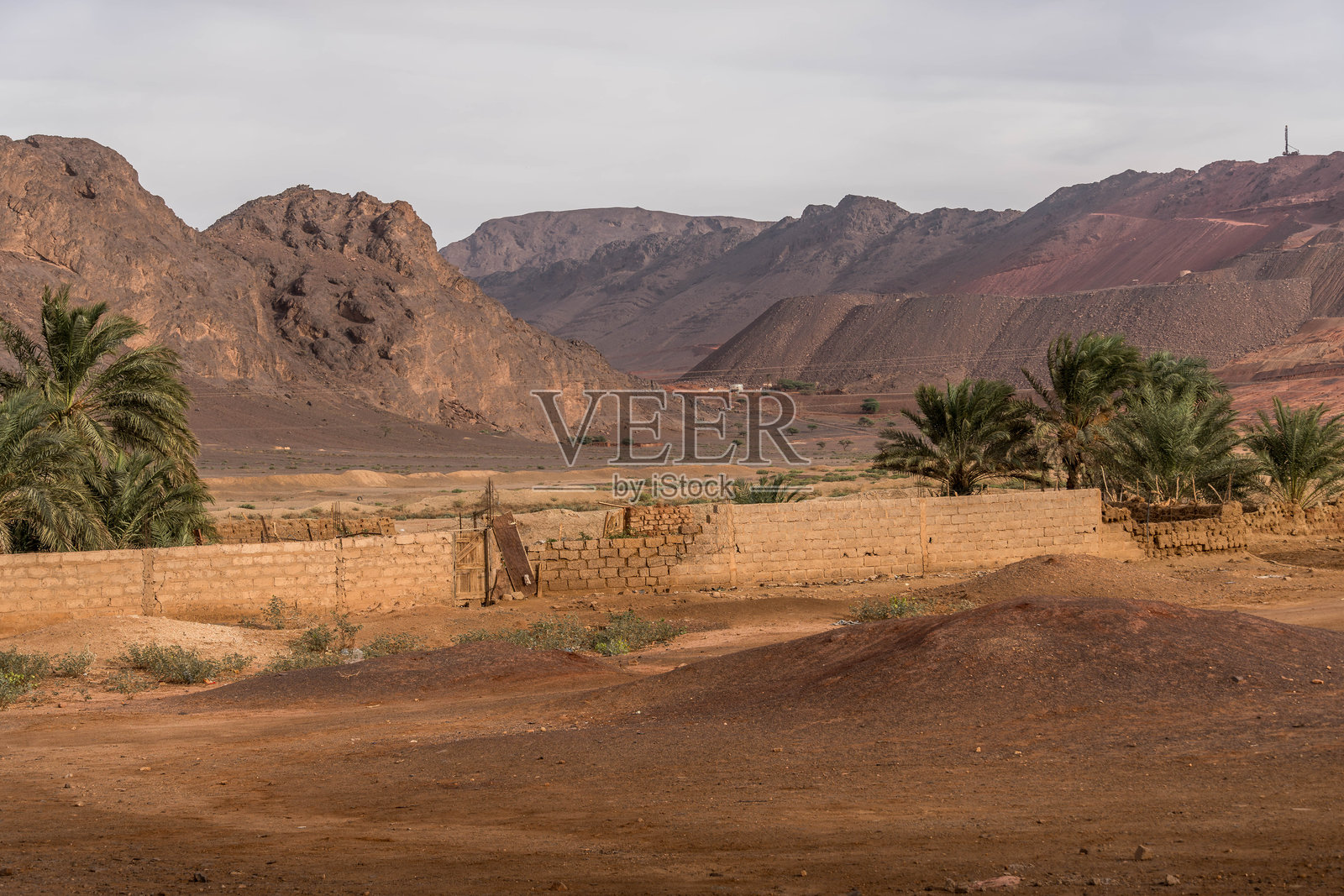 毛里塔尼亚的费德里克：撒哈拉沙漠小镇，位于煤渣山丘下；泥砖房屋，稀疏的街道，以及萨赫勒地区的社会困境照片摄影图片