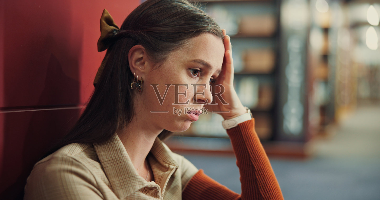 大学生，女孩在图书馆思考，因考试失败、难度大或疲惫而感到压力。教育、校园和因作业截止日期和工作负担压力而在地板上感到沮丧的人。照片摄影图片