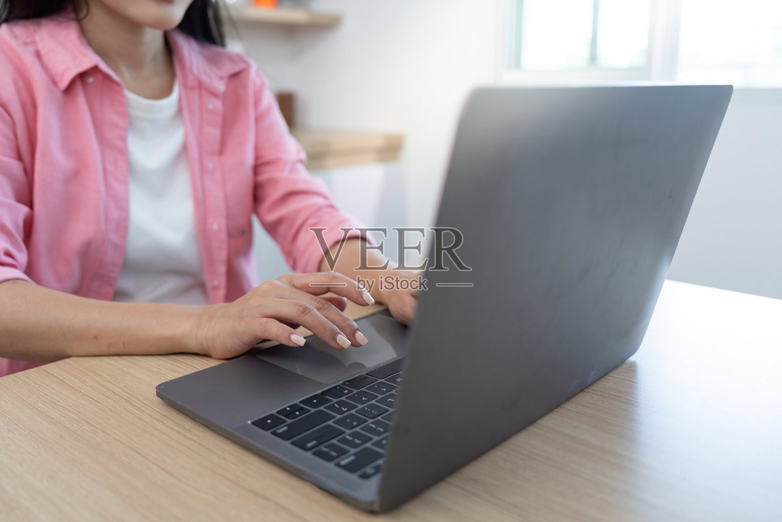 数字化转型：女性在家庭办公室使用笔记本电脑打字照片摄影图片