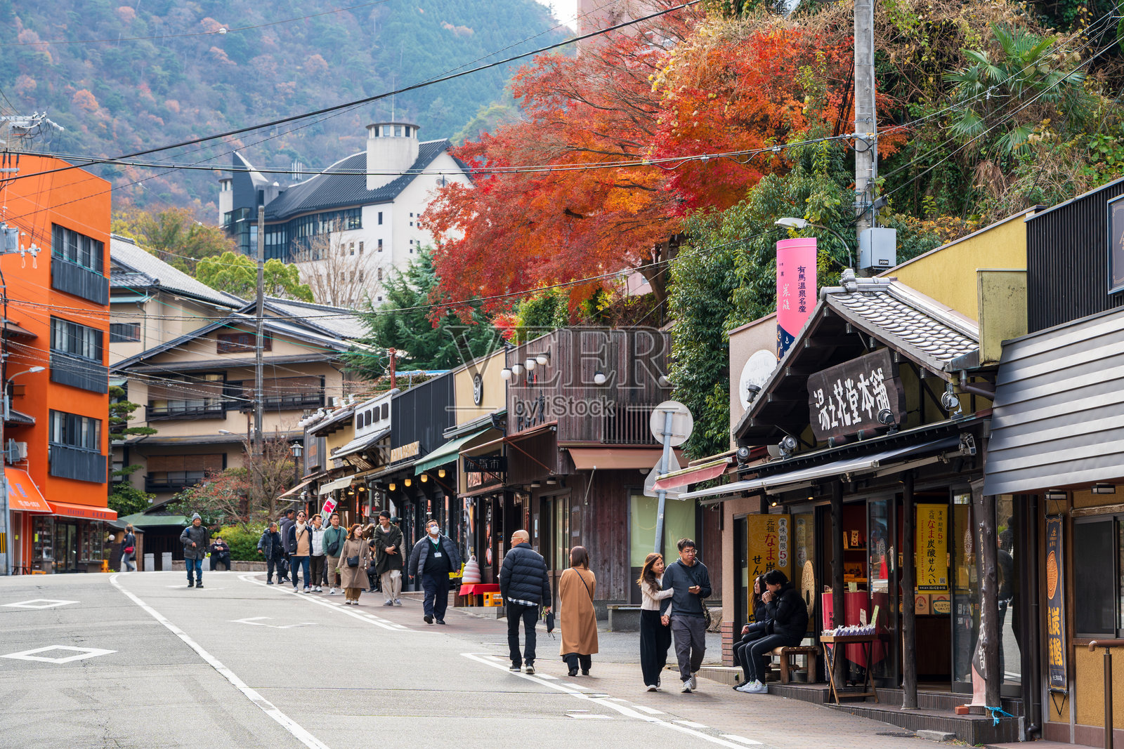 游客在秋叶环绕的有马街上漫步。日本兵库。照片摄影图片