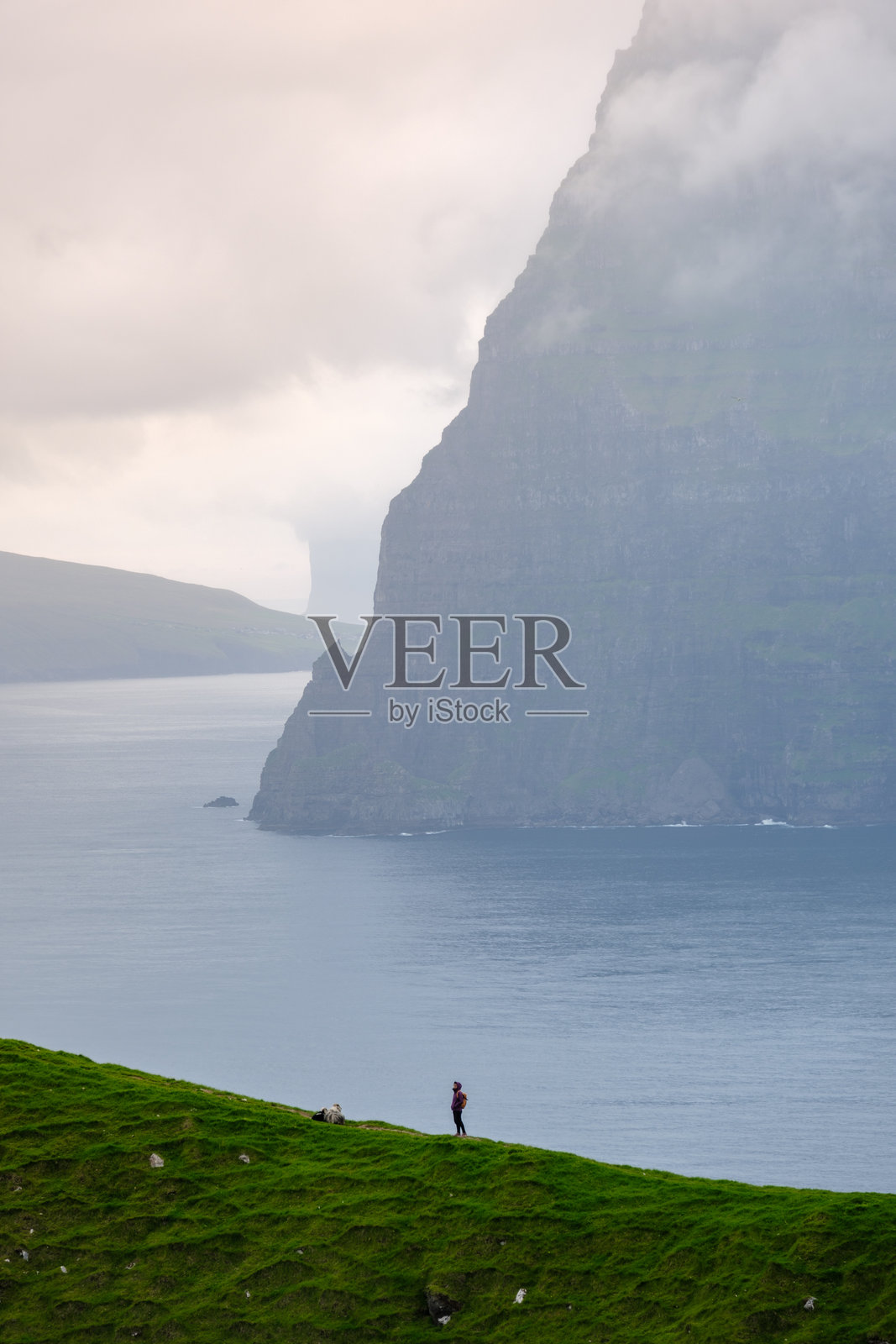 法罗群岛的悬崖和宁静的海水吸引冒险者探索自然之美照片摄影图片