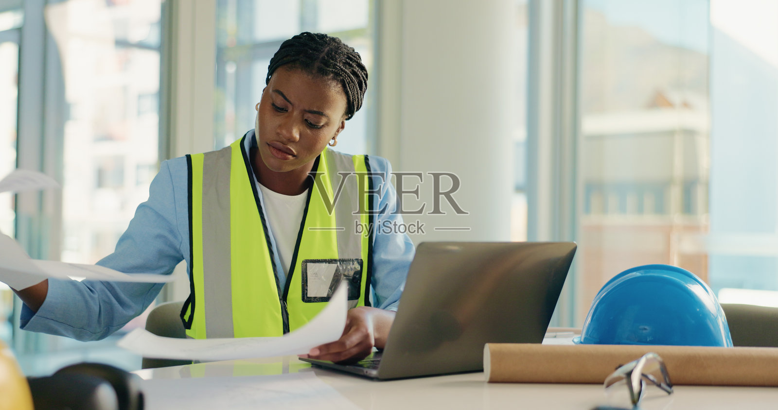 建筑、笔记本电脑和手持文件的女性，进行蓝图、建筑设计和平面图的工作。施工、土木工程师和在电脑前的人员，进行规划、研究和项目文件的处理。照片摄影图片