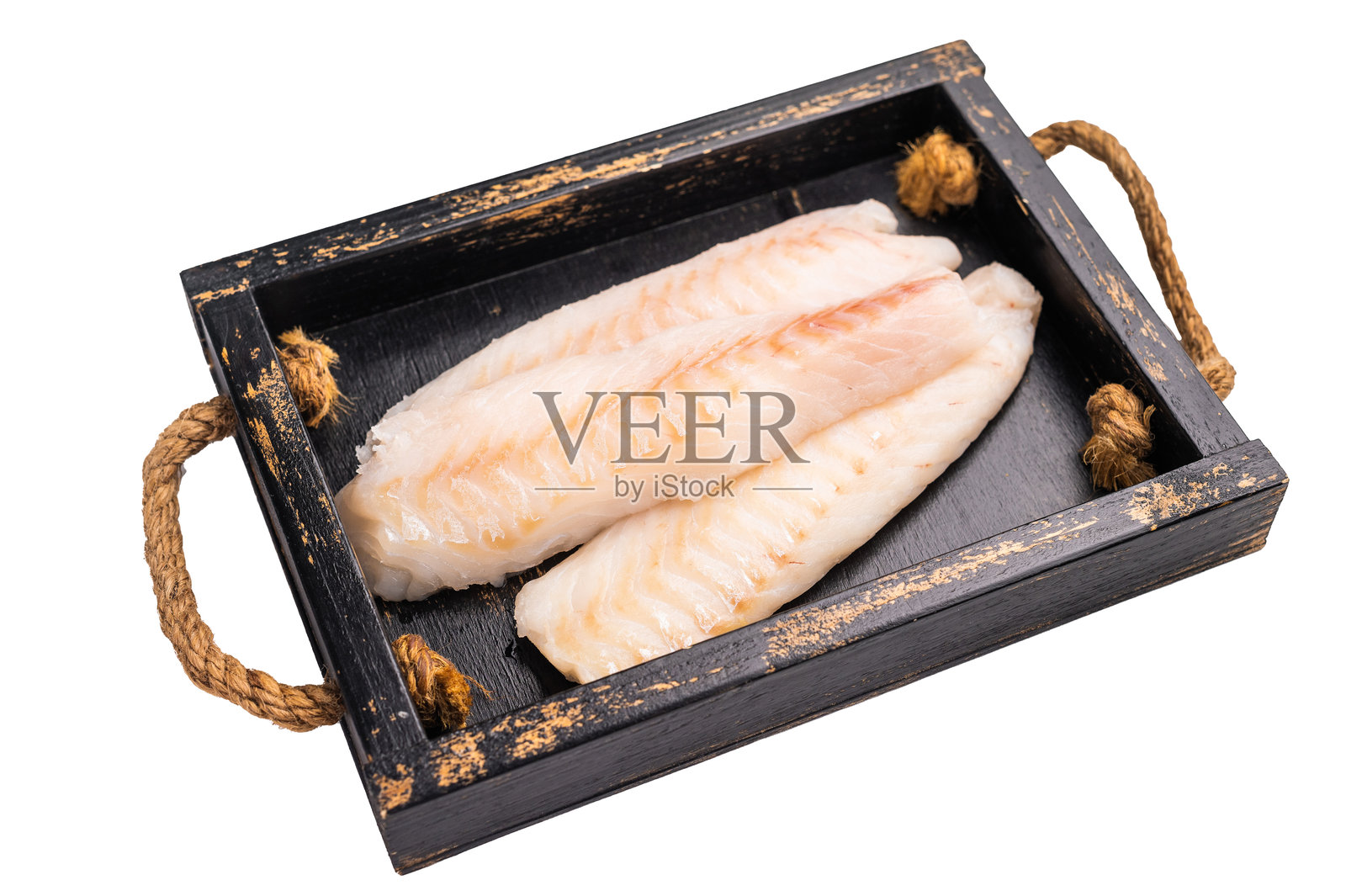 新鲜鱼肉，去皮的生鳕鱼里脊块放在木托盘中，背景为白色。照片摄影图片