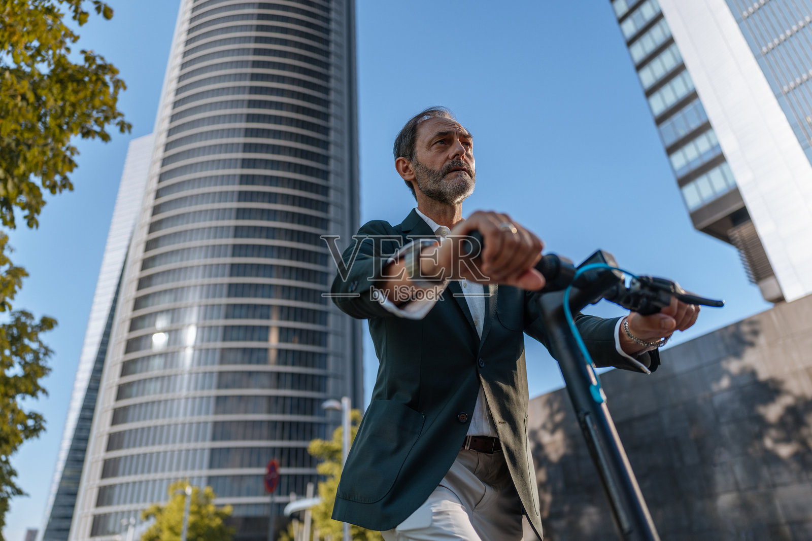 商人在马德里的四塔商务区骑电动滑板车照片摄影图片