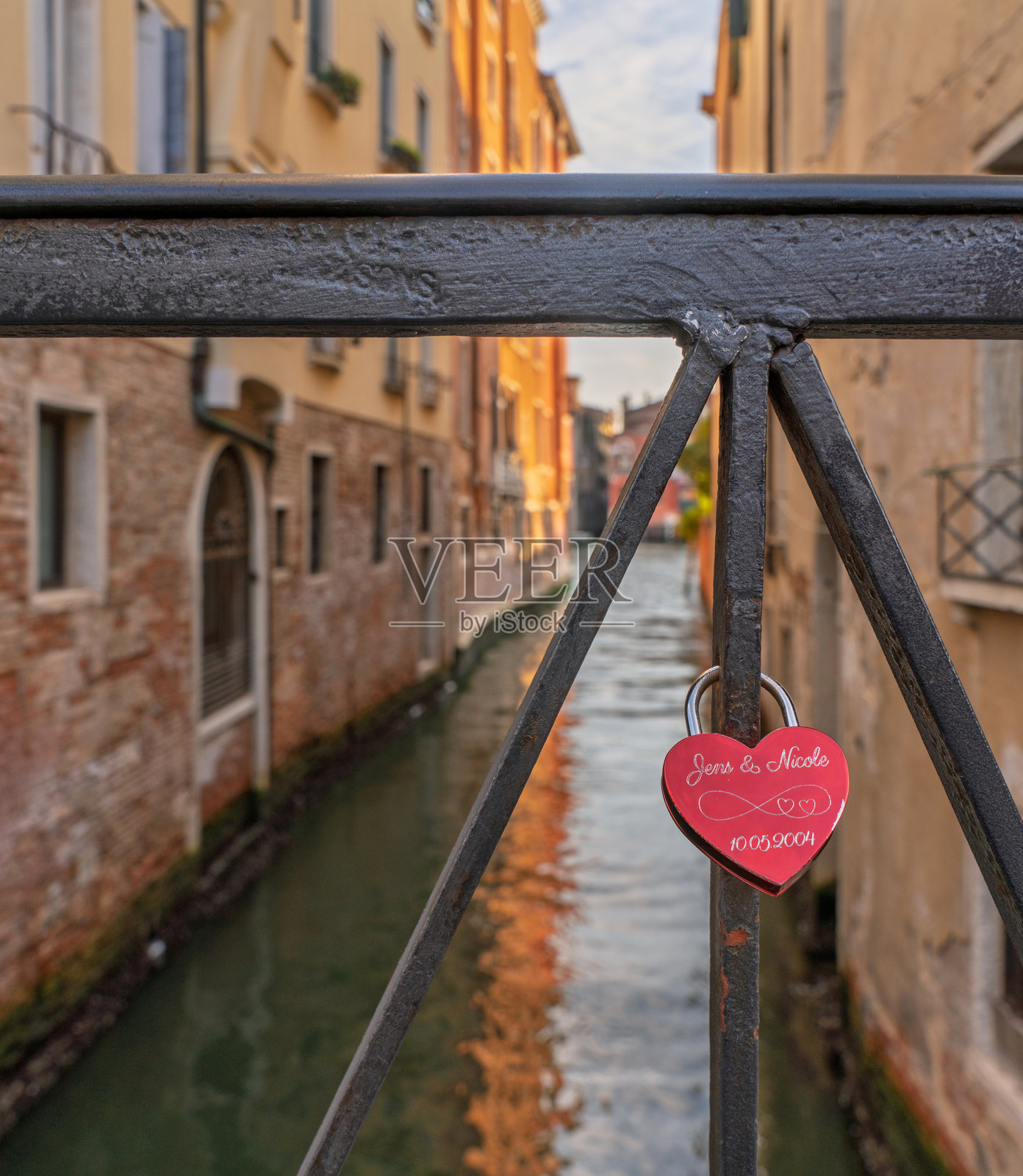 威尼斯运河上桥上的红色心形爱情锁照片摄影图片