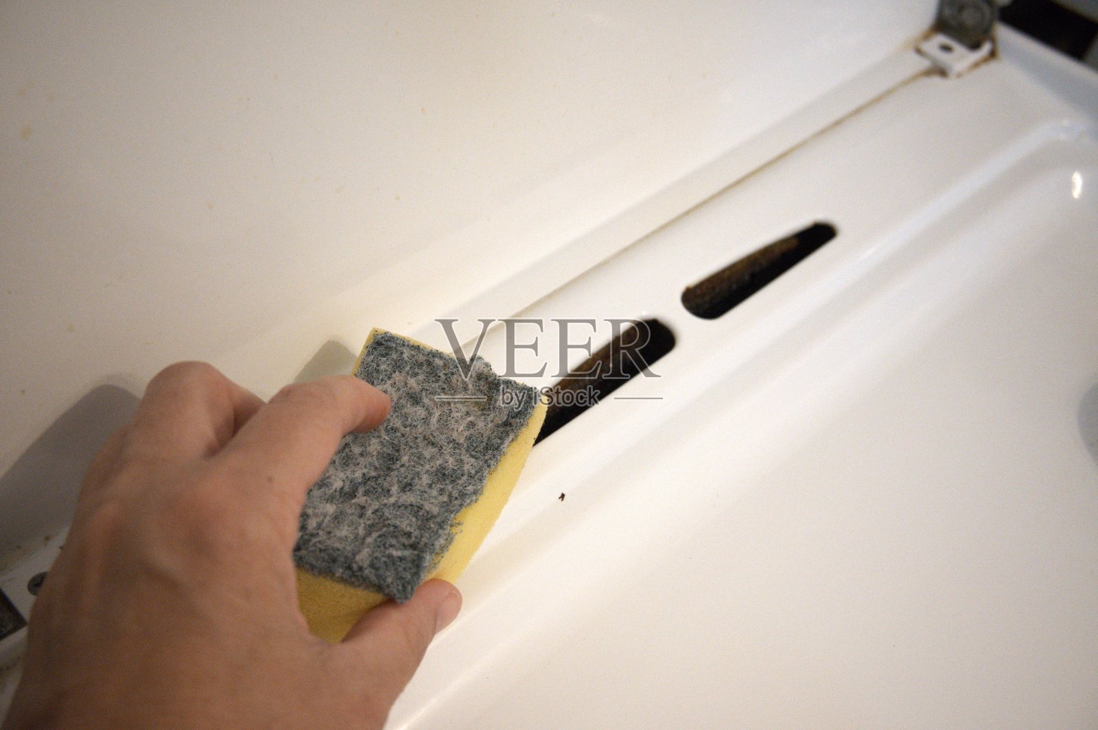 用海绵清洁燃气灶 - 特写照片摄影图片