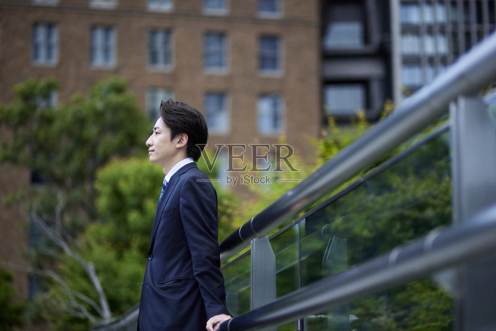 一位身穿西装的日本男子在商业区凝视远方照片摄影图片