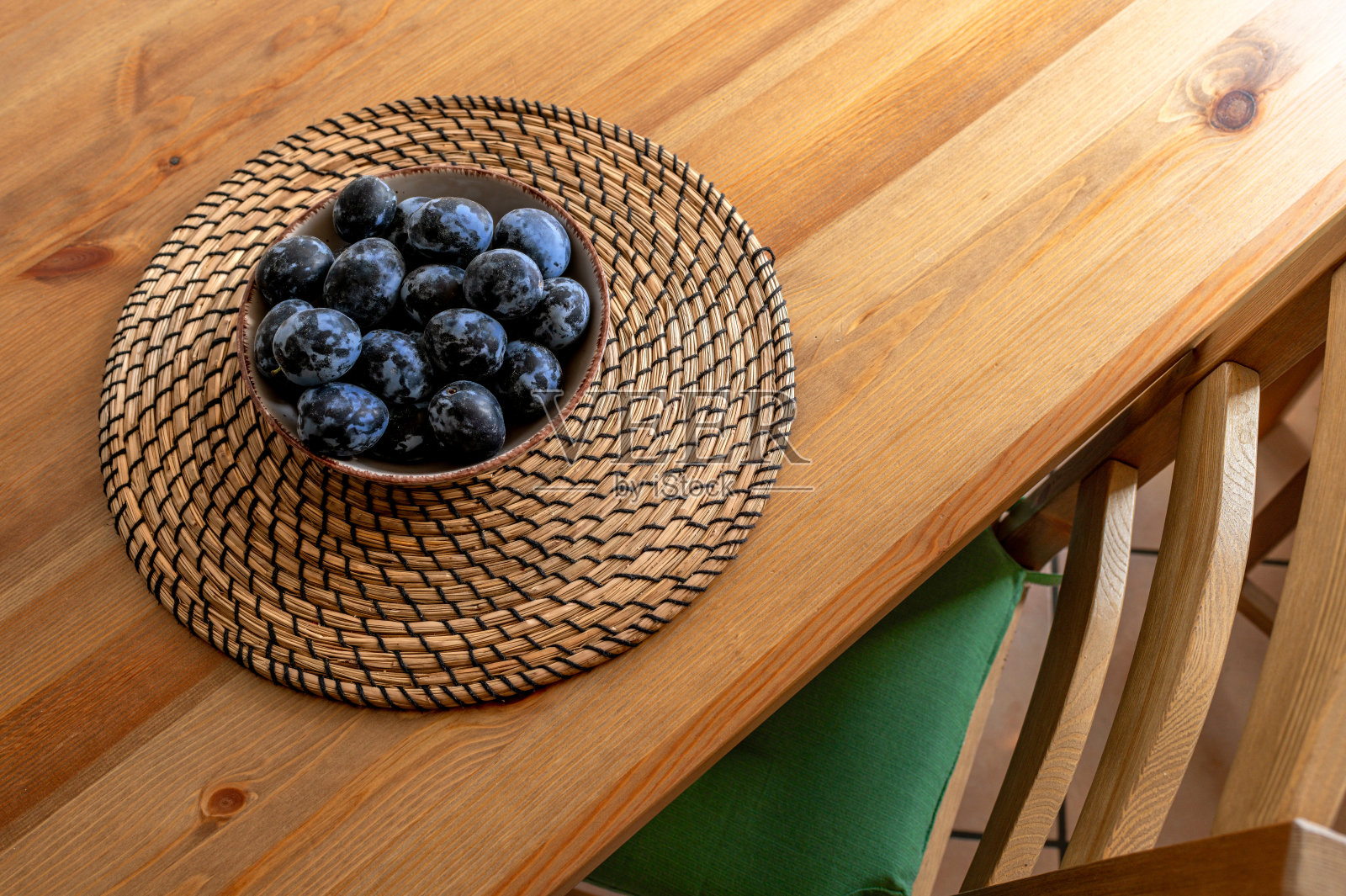 木桌上的新鲜李子碗照片摄影图片