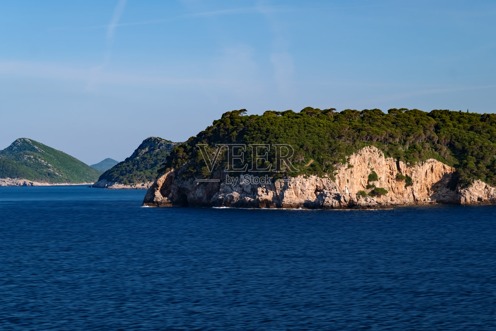 克罗地亚达尔马提亚日出时的杜布罗夫尼克群岛和远处的山脉，海上视角照片摄影图片