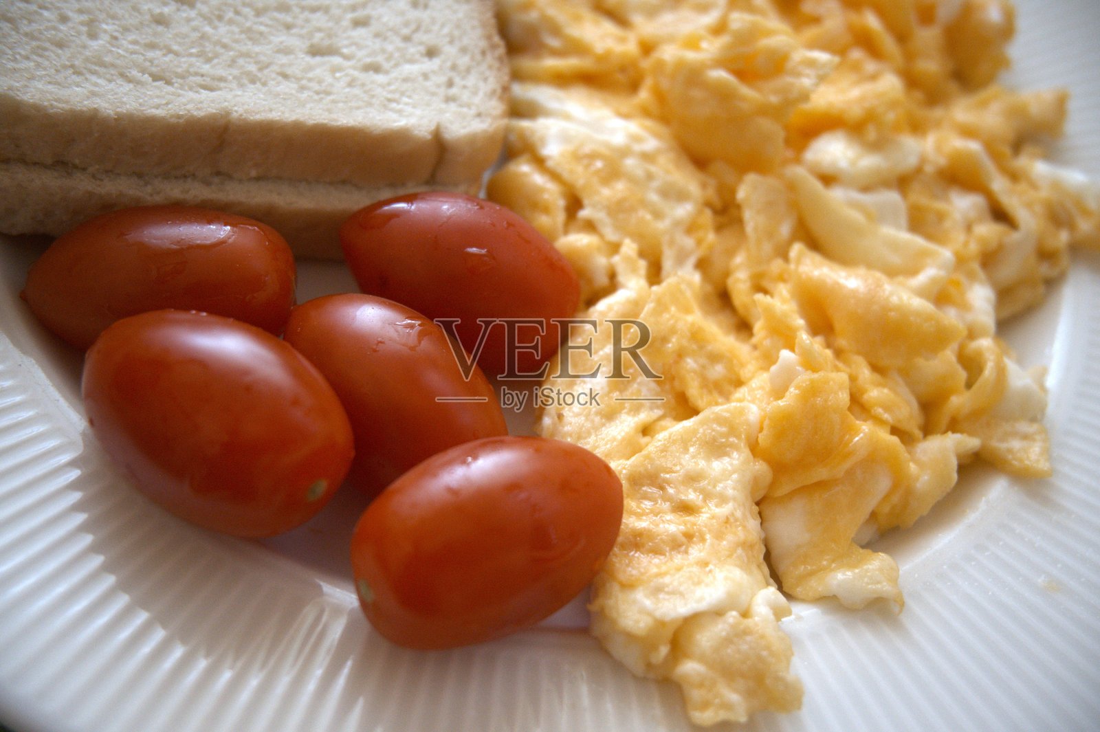 健康早餐：炒鸡蛋、番茄和面包照片摄影图片