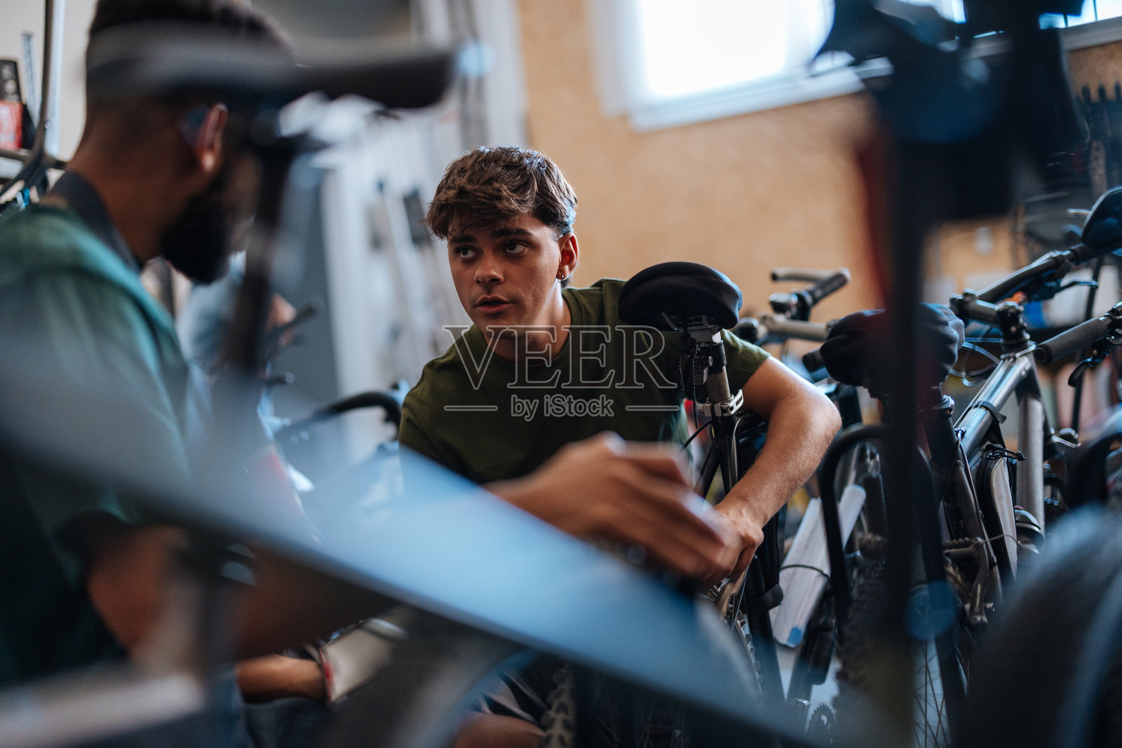 自行车修理工在车间讨论维修事宜照片摄影图片