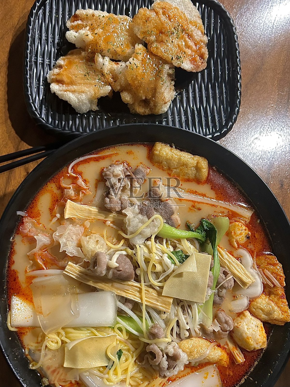 麻辣烫，搭配新鲜食材和浓郁的四川汤底，再加上酥脆酸爽的锅包肉。大胆的辣味与酸甜的口感完美平衡，适合一场中国盛宴。照片摄影图片