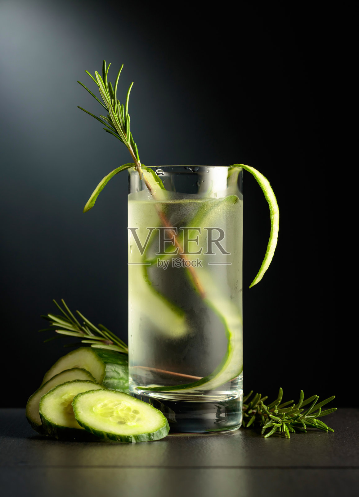 冰镇清爽饮料，配有冰块、黄瓜和迷迭香。照片摄影图片