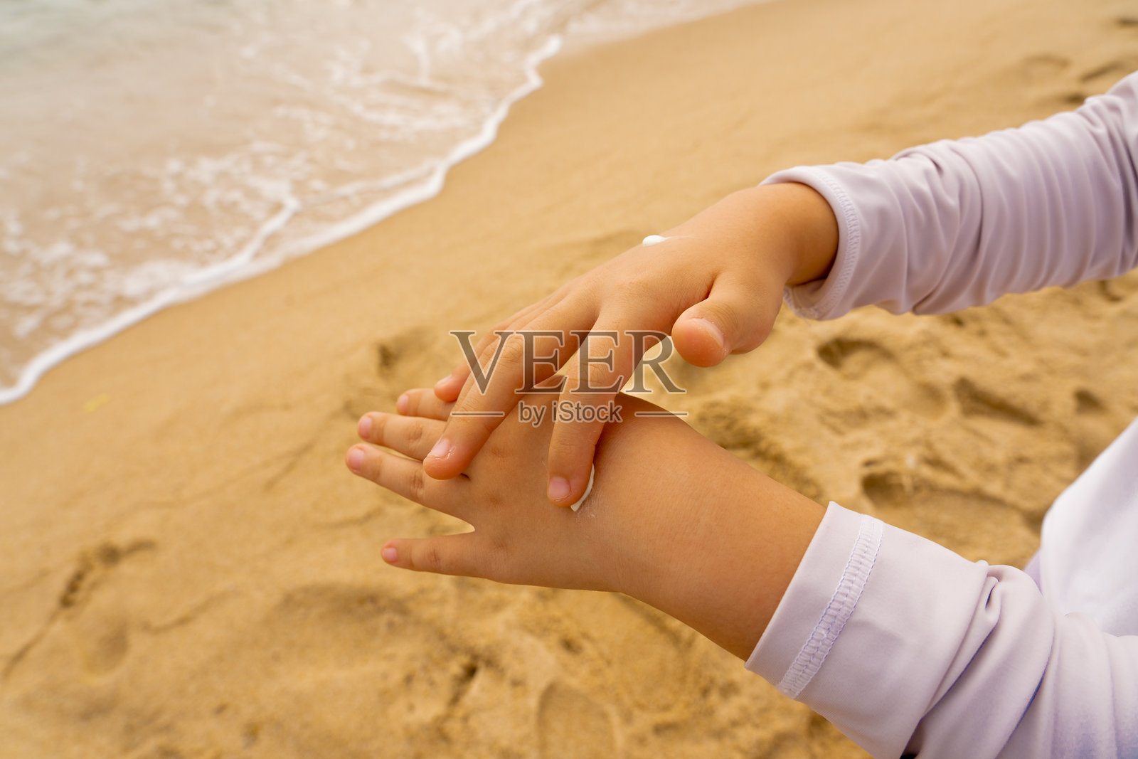 孩子在手上涂抹防晒霜照片摄影图片