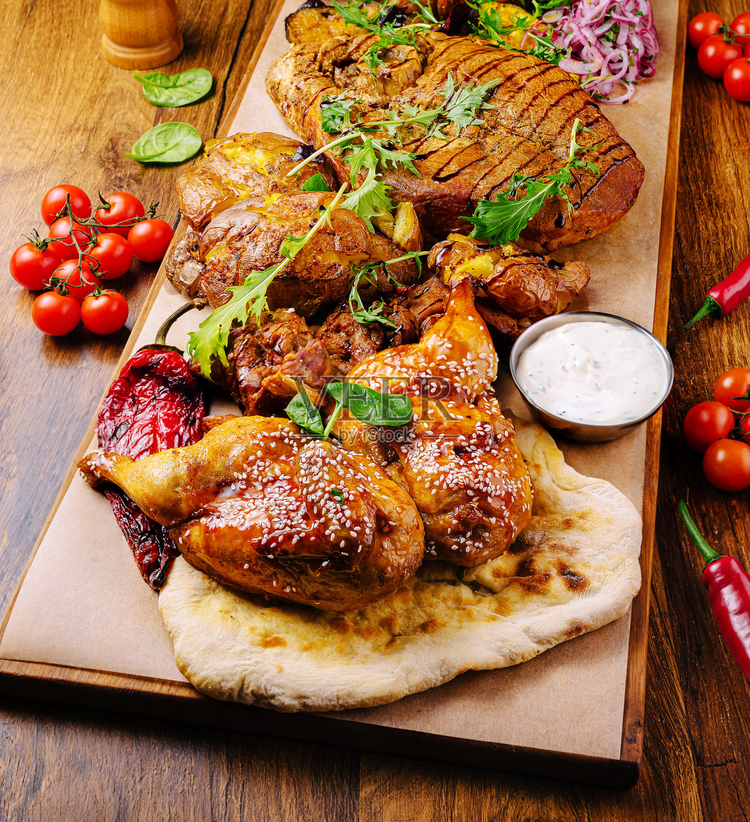 温馨地点的烤肉拼盘，配有新鲜香草和鲜艳的装饰照片摄影图片